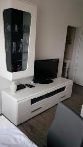 a white entertainment center with a flat screen tv on it at Wohlfühlort in Zwenkau