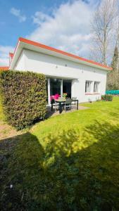 ein Haus mit einem Picknicktisch im Hof in der Unterkunft Villa avec jardin aux portes du Touquet Paris-Plage in Cucq