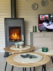 duas mesas em frente a uma lareira com uma televisão em Vakantiehuis Germaine em Middelkerke
