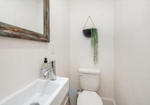 a bathroom with a toilet and a sink and a mirror at Mid Century Modern Boise-River Bungalow w/ Hot Tub in Boise +29 photos