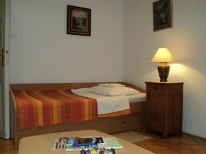 Apartment Horvat في زغرب: غرفة نوم بسرير ومصباح على طاولة