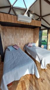 two beds in a room with a window at Glamping Domo Pullao in Castro