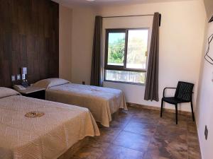 a hotel room with two beds and a window at Hotel Conquistador in Mazatlán