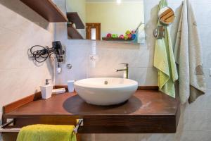 a bathroom with a white bowl sink on a wooden counter at Solemarevacanze Villasimius in Villasimius +10 photos