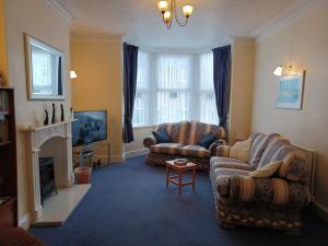 a living room with two couches and a fireplace at Palm Court in Weymouth