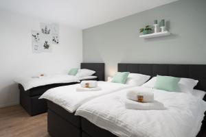 2 Betten in einem weiß-grünen Zimmer in der Unterkunft Aparte - Washer & Dryer - Kitchen & Parking - Smart-TV in Sarstedt