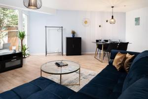 ein Wohnzimmer mit einem blauen Sofa und einem Tisch in der Unterkunft Aparte - Washer & Dryer - Kitchen & Parking - Smart-TV in Sarstedt
