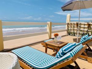 eine Terrasse mit Tisch und Stühlen sowie Strand in der Unterkunft Paraíso na areia da praia in Maceió