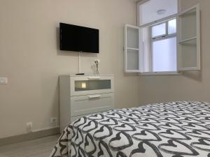 a bedroom with a bed and a flat screen tv at Casa Pablo II Aptº Tranquilo, a cinco minutos del Puerto de la Cruz in Los Realejos