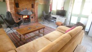 a living room with a couch and a fireplace at Le Chaumont in Theux