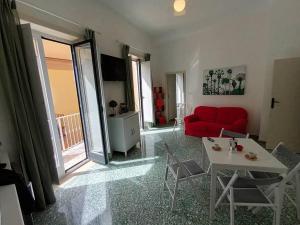 a living room with a red couch and a table at Green Apartment in Sorrento coast in Massa Lubrense