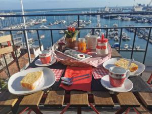 a table with food and coffee on a balcony with a harbor at CASA D'AMARE in Salerno