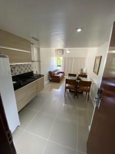 cocina y sala de estar con mesa y sillas en Apart Hotel em Ondina, en Salvador