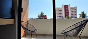 dwa krzesła siedzące na balkonie w obiekcie Hotel Kavia Mazatlán w mieście Mazatlán