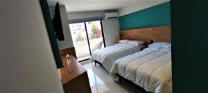Hotel Kavia Mazatlán في مازاتلان: غرفة نوم بسريرين ونافذة كبيرة