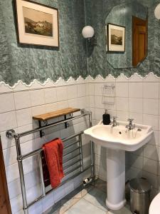 a bathroom with a sink and a mirror at Cowden Farmhouse, near Stonehaven. in Glenbervie