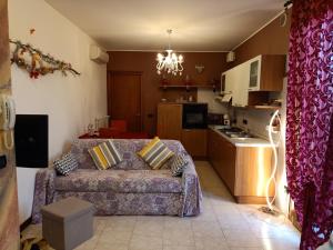 a living room with a couch and a kitchen at MB Place Abano Terme in Abano Terme