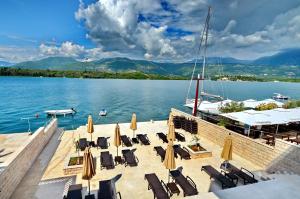 un gruppo di sedie e ombrelloni su un molo sul lago di Apartments Bojana a Tivat