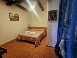 a bedroom with two beds and a blue curtain at Le Casette di Nino in Marina di Camerota