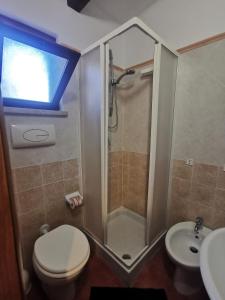 a bathroom with a shower and a toilet and a sink at Le Casette di Nino in Marina di Camerota