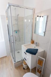 ein Bad mit einer Dusche und einem weißen Waschbecken in der Unterkunft 4 pers centre-ville / 300M Plage in Royan