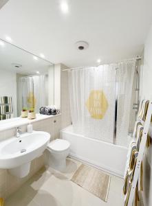 baño blanco con lavabo, bañera y aseo en Lovely 1 bedroom apartment in South East London, en Londres