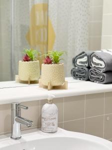 a bathroom sink with two potted plants on a shelf at Lovely 1 bedroom apartment in South East London in London