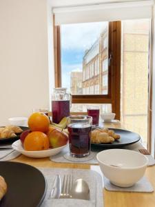 a table with plates of food and fruit on it at Lovely 1 bedroom apartment in South East London in London