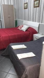 ナポリにあるTarsia Suiteのホテルルーム内のベッド2台(タオル付)