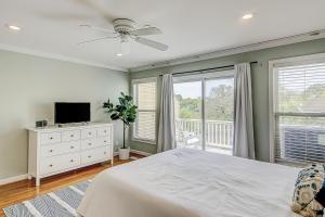 a bedroom with a bed and a television and a balcony at Turtle Bay 5 in Folly Beach