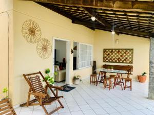 a patio with chairs and a table on a house at Casa duplex beira mar com caseiro de cortesia em Maceió in Maceió