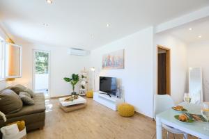 sala de estar con sofá y TV en Hedera Estate, Hedera A38, en Dubrovnik