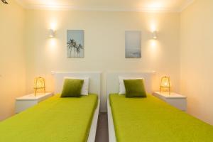 two beds in a room with green sheets at Casa do Afonso Cabanas Beach in Cabanas de Tavira +23 photos