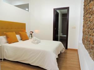 ein Schlafzimmer mit einem großen weißen Bett mit orangefarbenen Kissen in der Unterkunft Casa Aurea-Apartamento zona antigua,parking y wifi by DeLabra Apartments in Oviedo