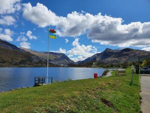 a flag on a pole next to a lake at Meirionfa great base for Snowdon in Llanberis