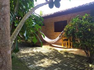 a hammock in front of a house at Chalés Hibiscus Pipa - ar, cozinha e banheiros privados, estacionamento interno in Pipa +18 photos
