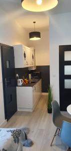 a kitchen with white cabinets and a table and chairs at Apartamenty u Krysi 2 in Ząb