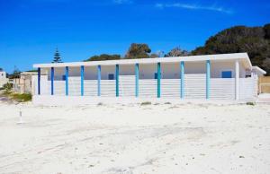 a white building on the beach next to the sand at Stabilimento Lido Burrone in Favignana