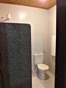 een badkamer met een toilet en een douche bij Chalés Hibiscus Pipa - ar, cozinha e banheiros privados, estacionamento interno in Pipa