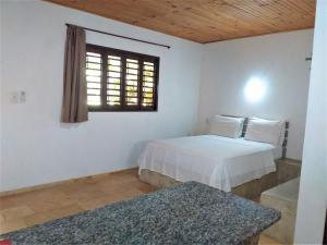 een slaapkamer met 2 bedden en een raam bij Chalés Hibiscus Pipa - ar, cozinha e banheiros privados, estacionamento interno in Pipa