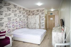 una camera da letto con un letto bianco e una parete coperta di firme di семеен хотел Прованс Ахелой ad Aheloy