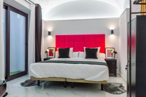 Schlafzimmer mit einem großen Bett mit einem roten Kopfteil in der Unterkunft Apartamentos Élite - Art Collection - Andy in Merida