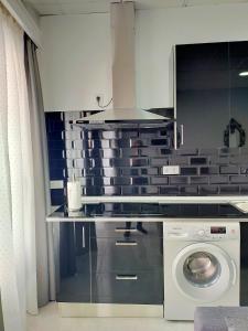 a kitchen with a washing machine and a stove at María y Juan Apartamento con Garaje in Sanlúcar de Barrameda