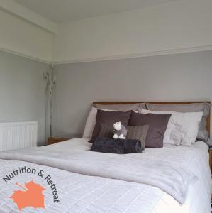uma cama com um urso de peluche sentado em cima dela em The Sycamores Nutrition & Retreat em Matlock