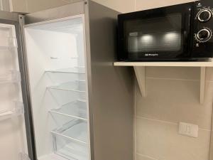 a microwave sitting on a shelf next to a refrigerator at Casa Pablo I Aptº Tranquilo,a cinco minutos del Puerto de la Cruz in Los Realejos