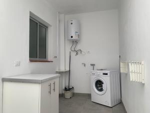 a white kitchen with a washing machine and a window at Casa Pablo I Aptº Tranquilo,a cinco minutos del Puerto de la Cruz in Los Realejos
