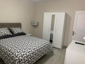 a bedroom with a black and white bed and a mirror at Casa Pablo I Aptº Tranquilo,a cinco minutos del Puerto de la Cruz in Los Realejos