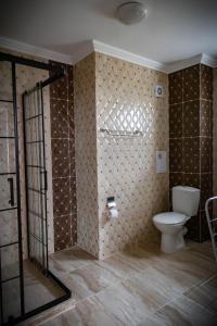 un bagno con servizi igienici e una parete con piastrelle di семеен хотел Прованс Ахелой ad Aheloy