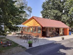 a building with chairs and tables and an umbrella at Apartmány Sluníčko in Nová Bystřice
