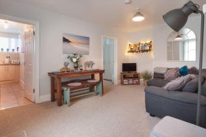 ein Wohnzimmer mit einem Sofa und einem Tisch in der Unterkunft Picturesque Mews Apartment Perfect Location Steps From Harbour and Beaches in Torquay